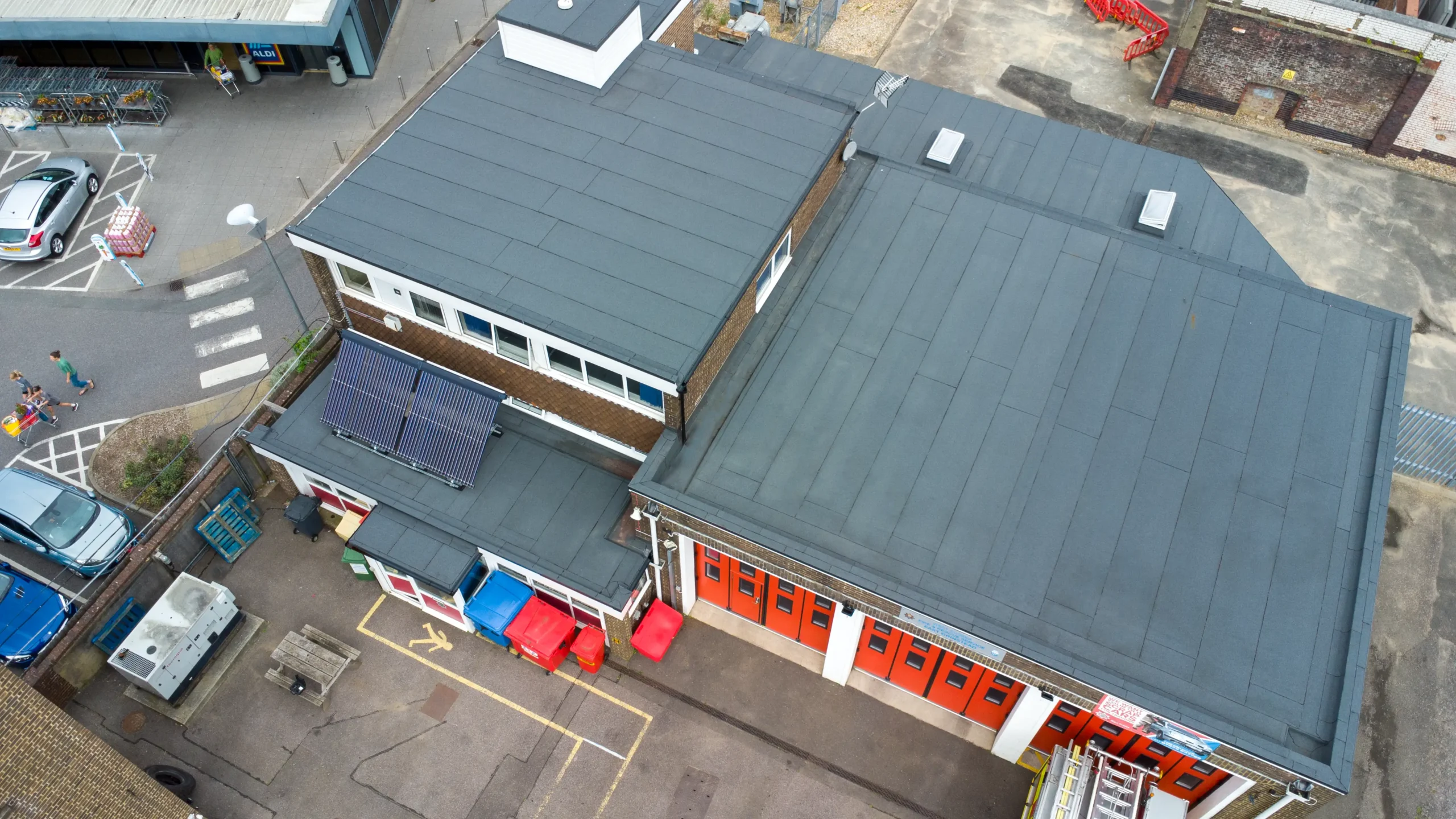 Aerial view East Grinstead fire station with gray roof and red doors
