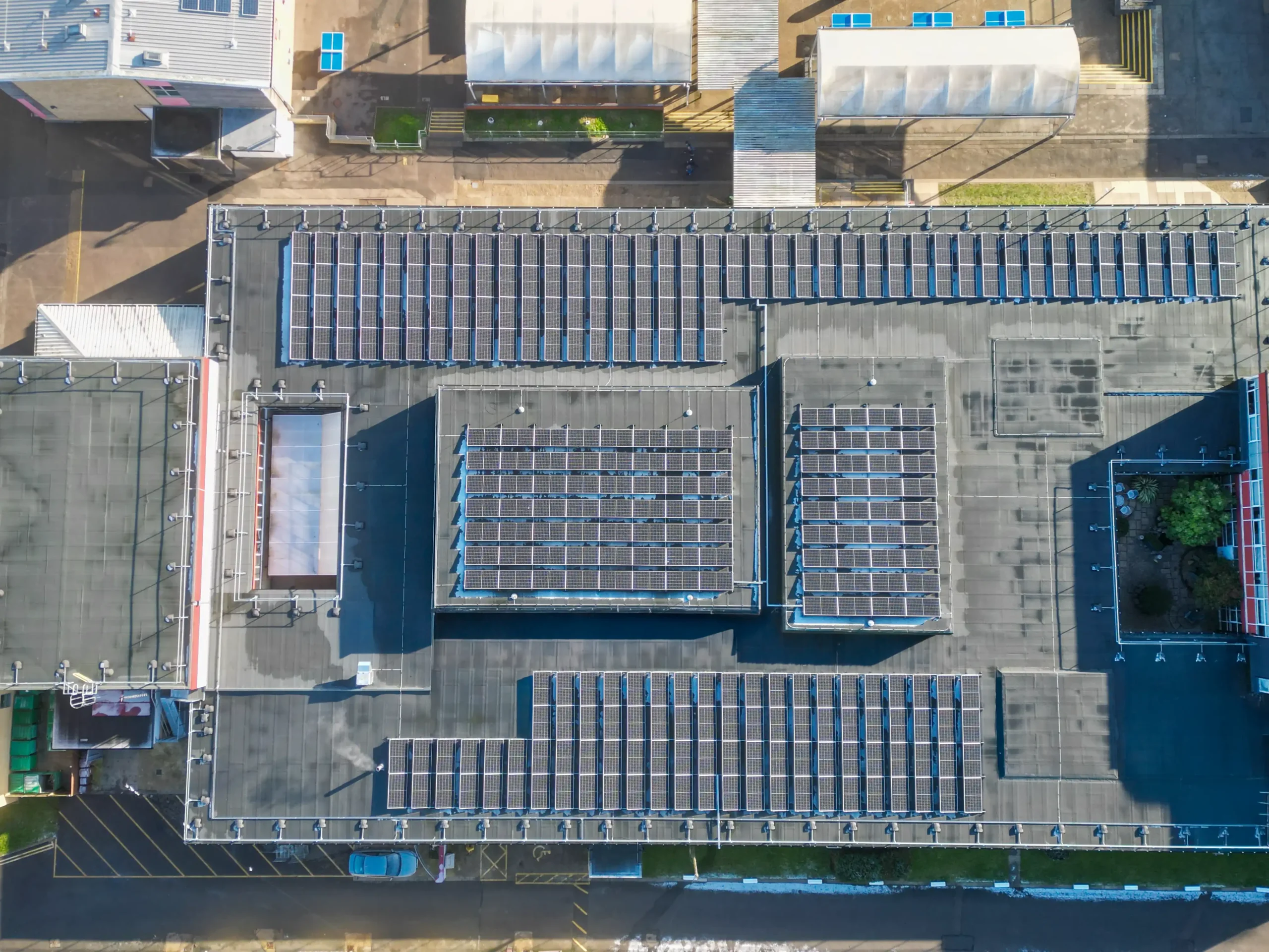 Aerial view of school building with extensive rooftop solar panel arrays installed