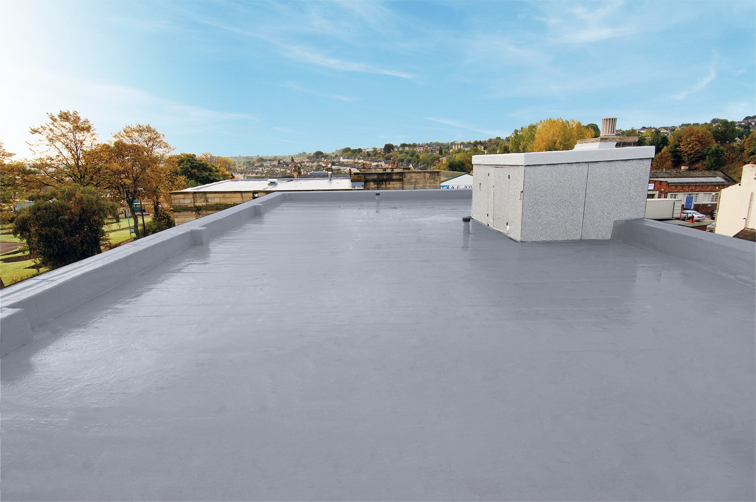 Flat roofing membrane installation on modern hospital building overlooking river
