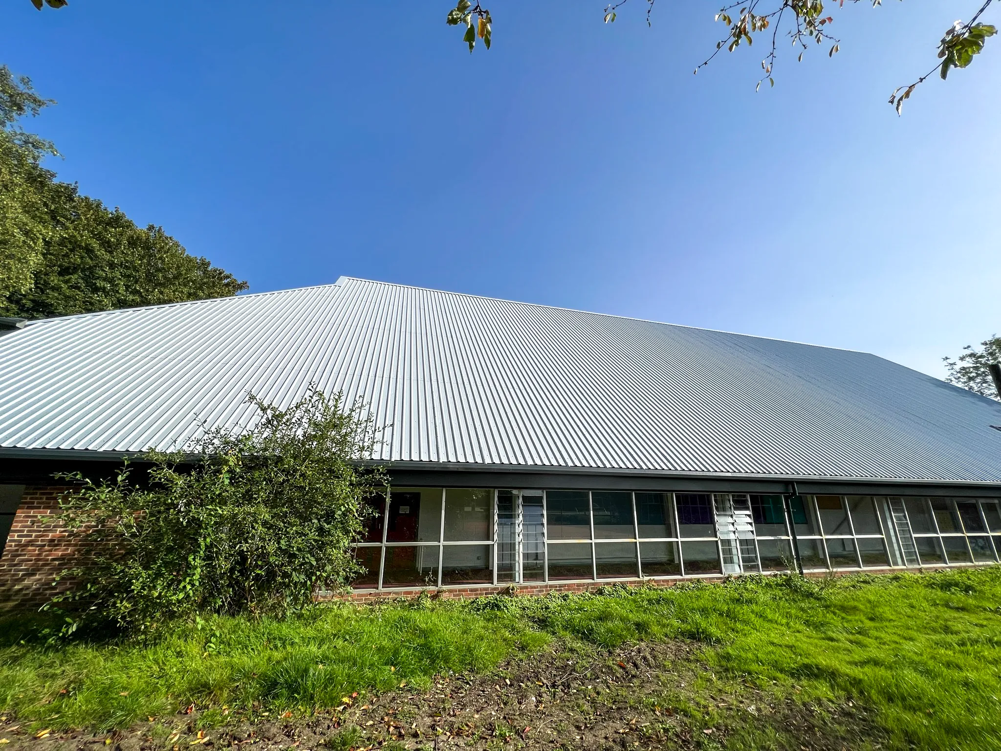 Modern sports hall with corrugated metal roof and brick facade exterior