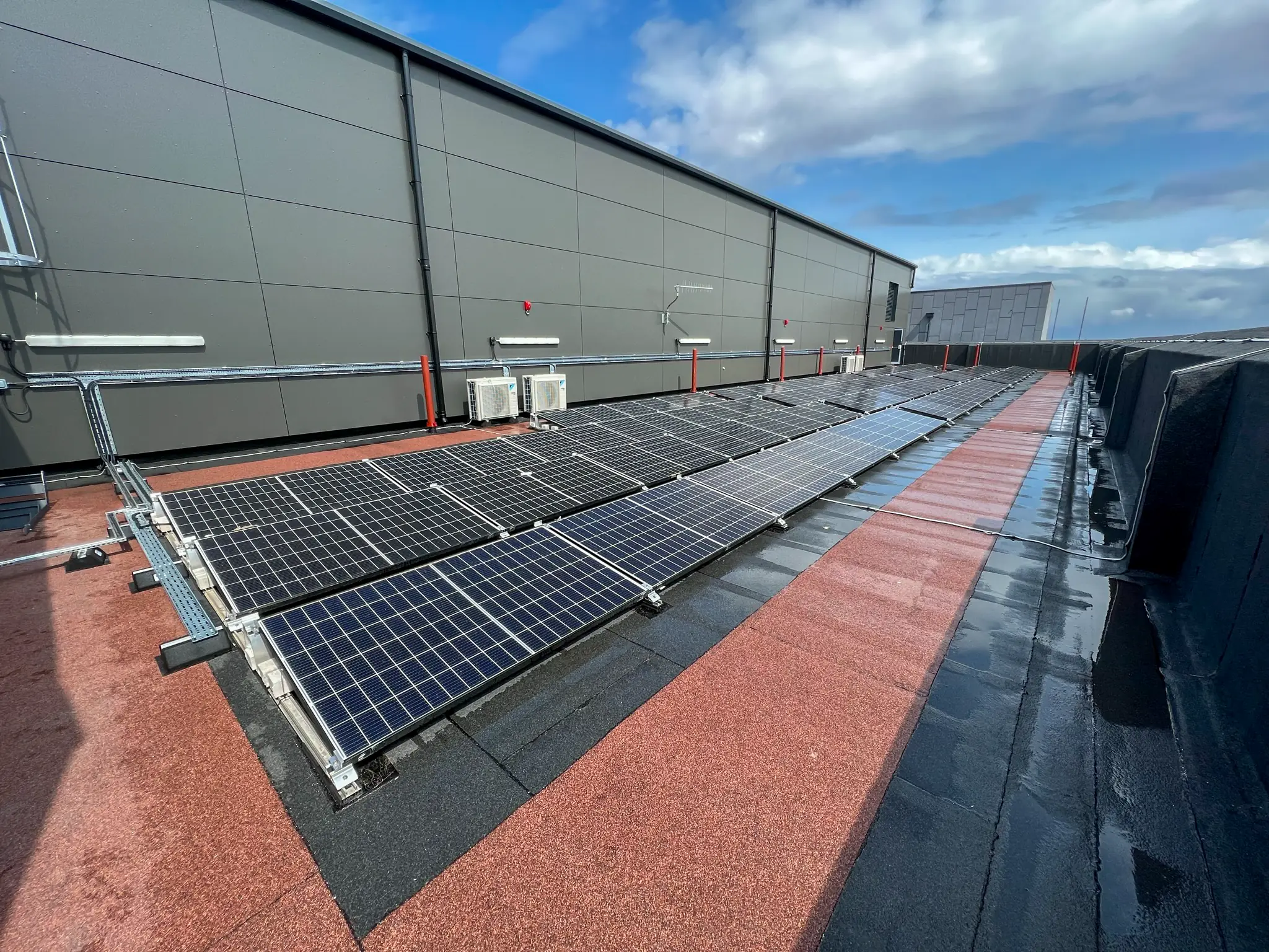 Solar panels installed on hospital rooftop with industrial building facade