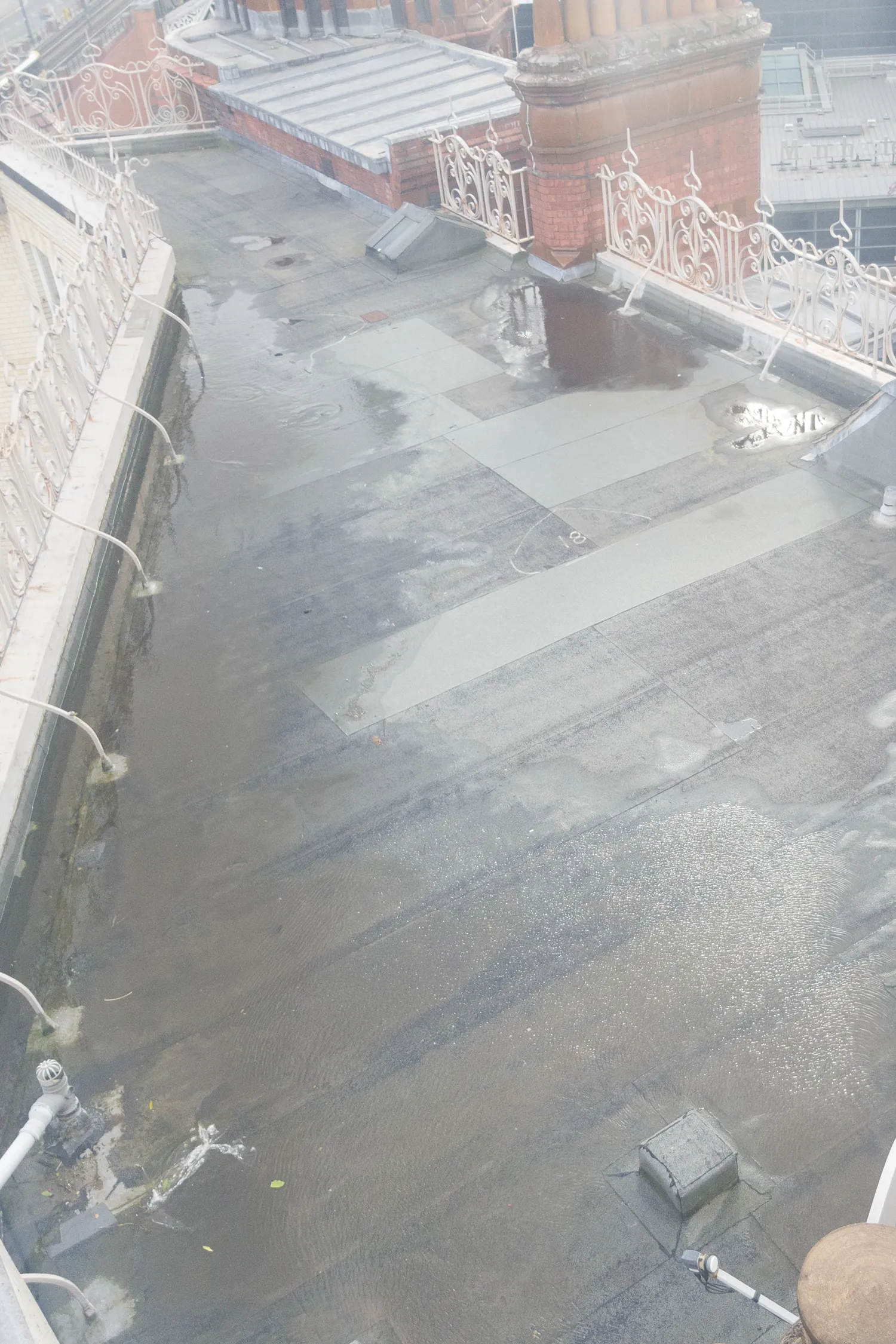 Aerial view of flooded courtyard at historic brick building with ornate railings