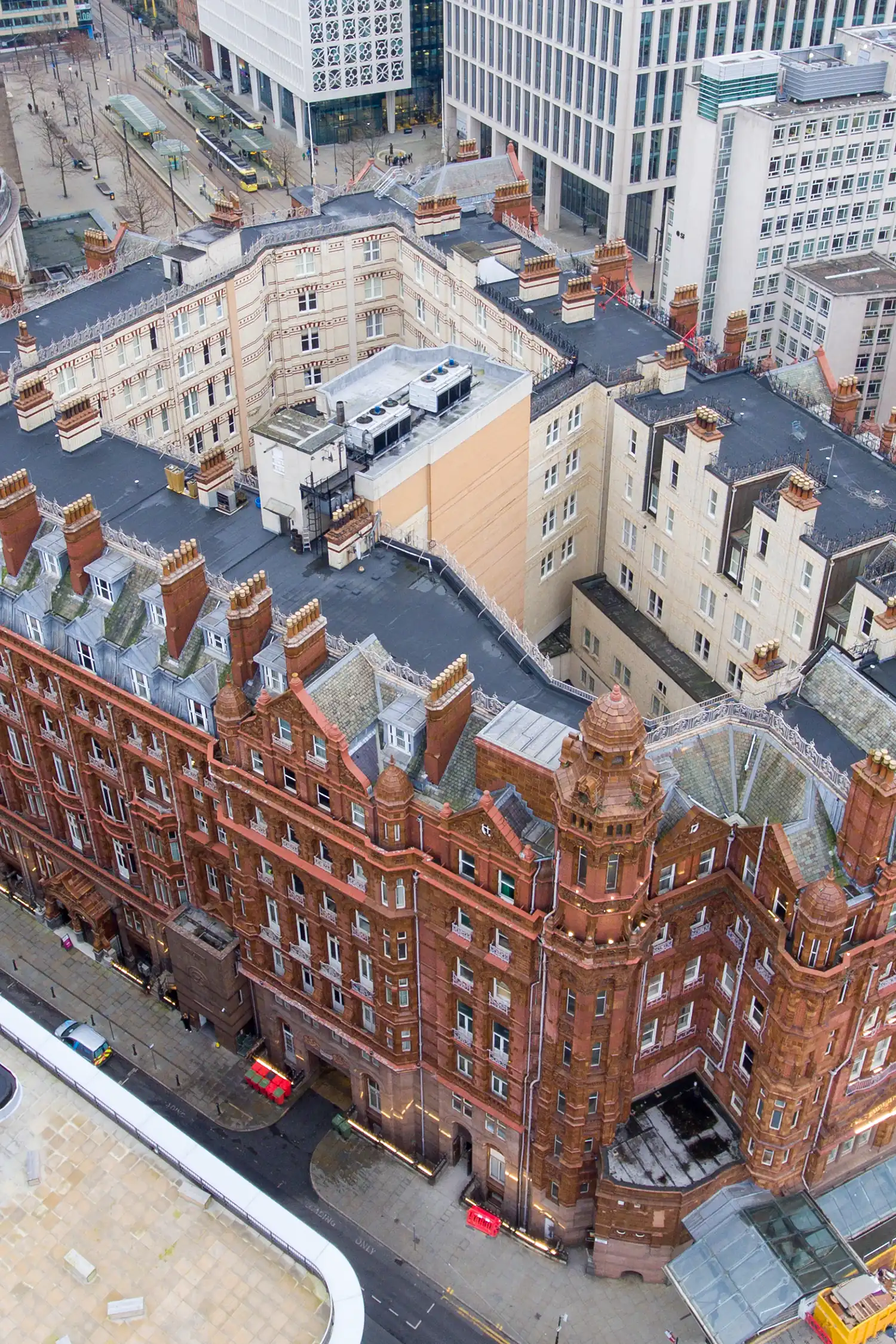 Aerial view of historic red brick Midland Hotel surrounded by modern office buildings