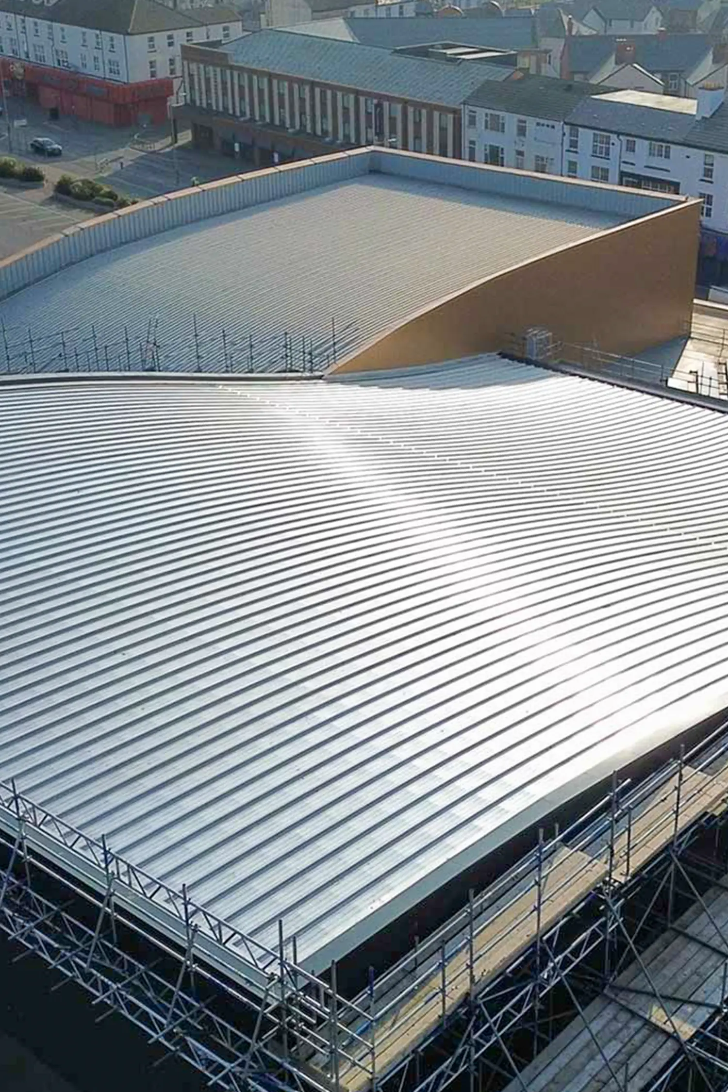 Aerial view of commercial waterpark facility with metal roofing and pool structures
