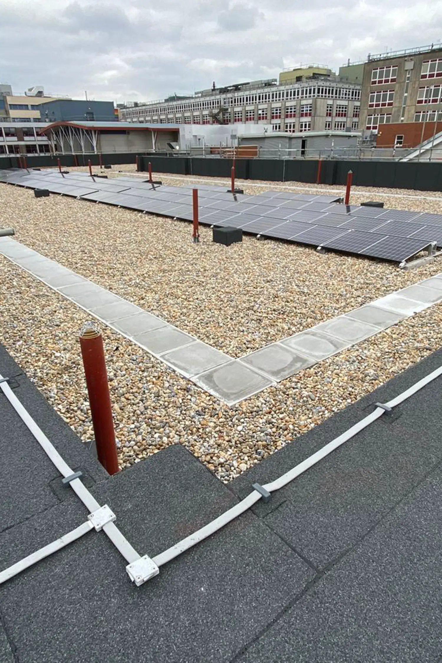 Rooftop solar panels installation on hospital building with gravel surface