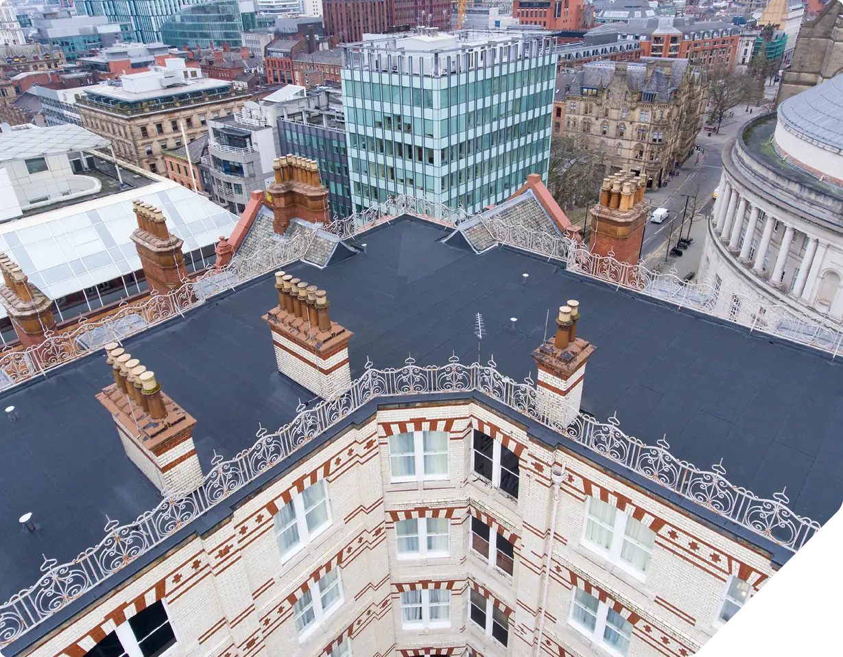 Aerial view Midland Hotel rooftop with ornate chimneys and Manchester cityscape
